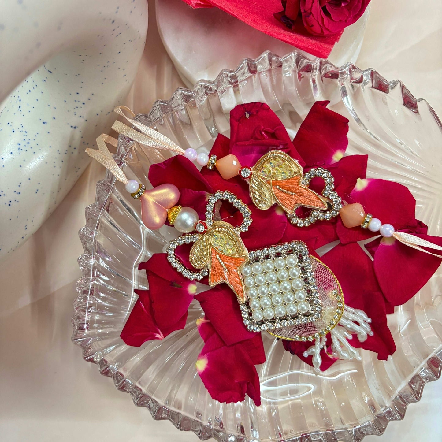 Bhaiya Bhabhi Rakhi Set Designer Raksha Bandhan Rakhi Combo displayed on rose petals in decorative bowl