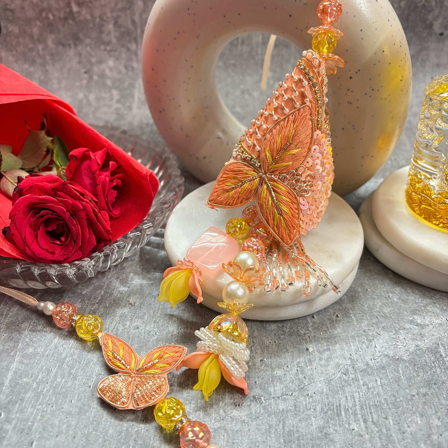 Designer Butterfly Rakhi with Latkan Rakhi for Bhaiya Bhabhi displayed with red roses and festive decor