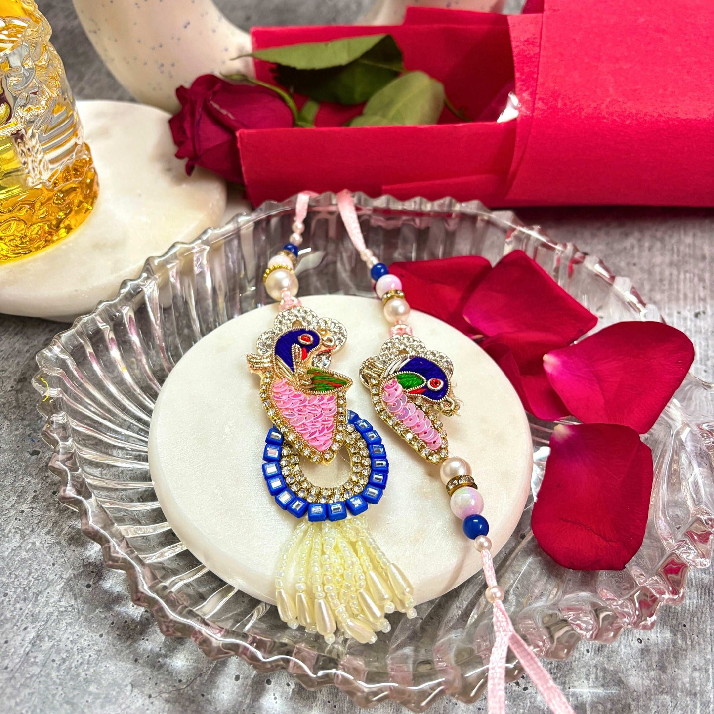 Handmade Peacock Rakhi Set for brother with vibrant colors and intricate designs on a decorative plate