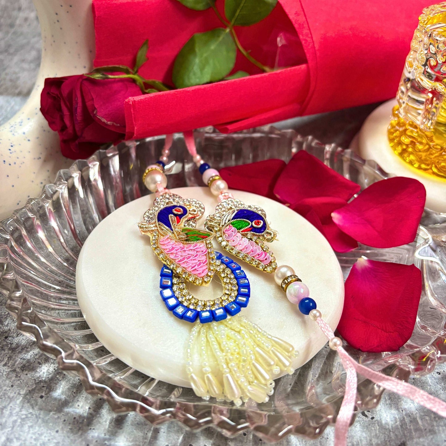 Handmade Peacock Rakhi Set for brother featuring colorful peacock designs on a decorative plate