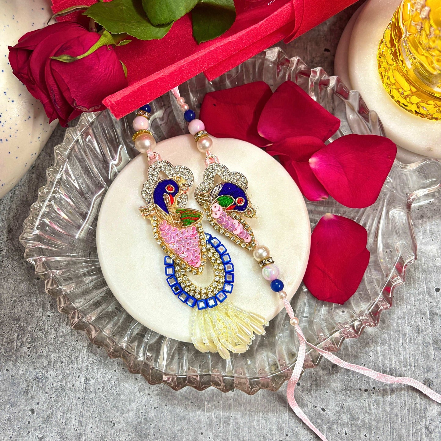 Handmade Peacock Rakhi Set for brother featuring intricate designs and vibrant colors on a decorative plate