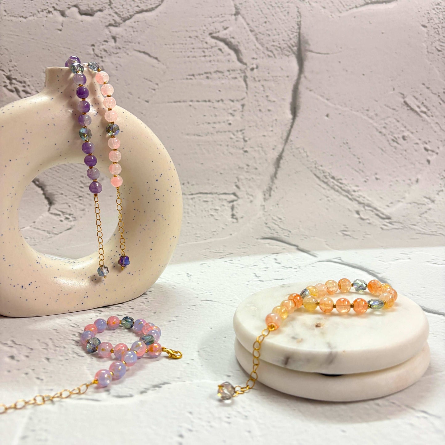 Set of four Marble Effect Beaded Bracelet Combo displayed on marble coasters with colorful designs