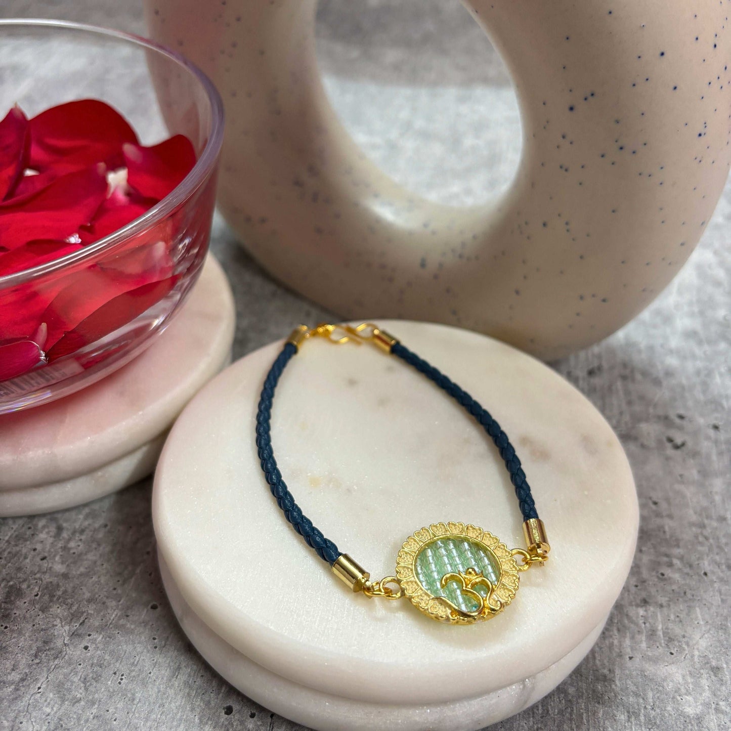 Om Symbol Rakhi from TyohaarVibe for Raksha Bandhan with intricate gold detailing on a blue braided band