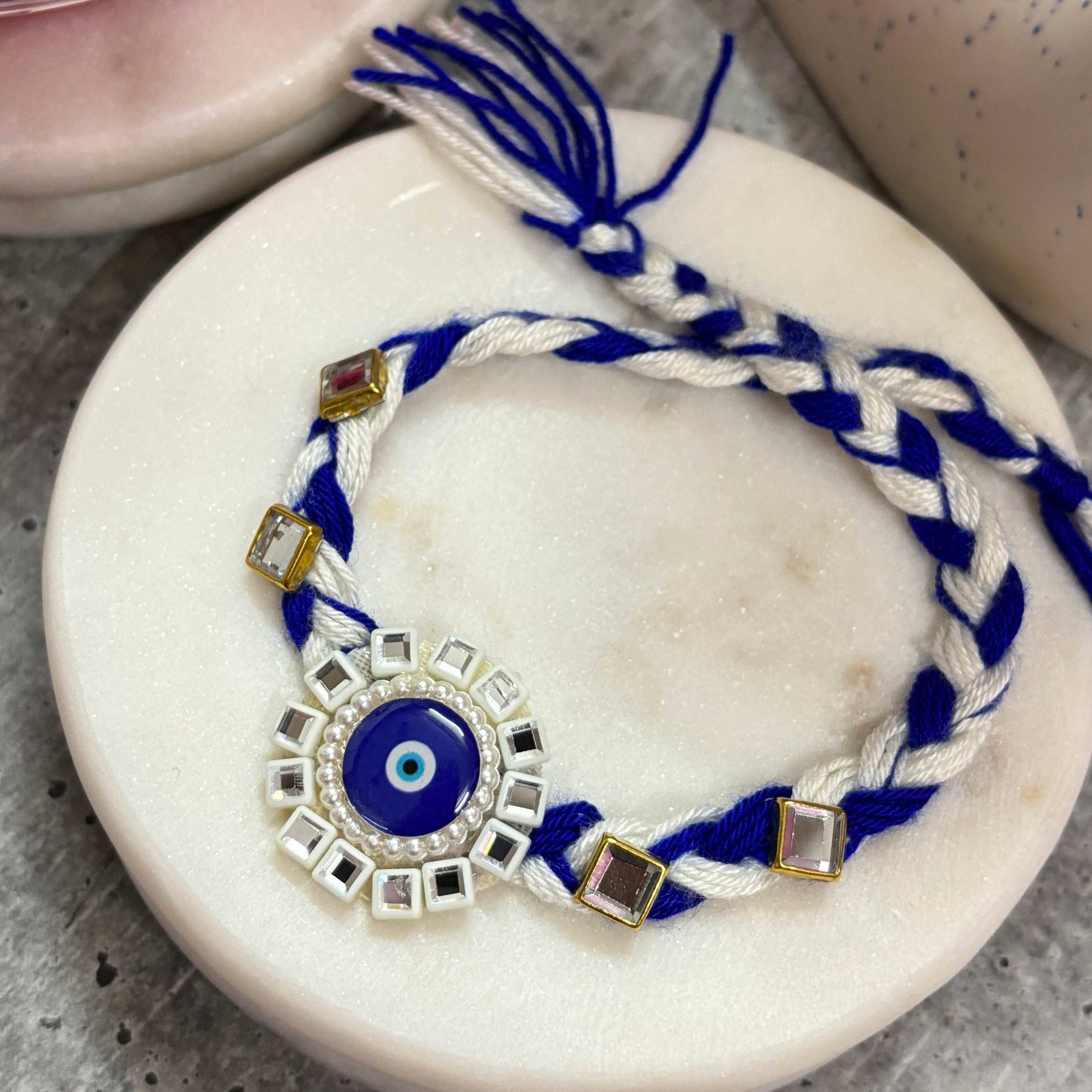 Evil Eye Designer Rakhi Raksha Bandhan 2025 with Braided Blue and White Threads and Decorative Charms