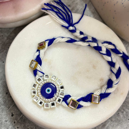 Evil Eye Designer Rakhi Raksha Bandhan 2025 with Braided Blue and White Threads and Decorative Charms